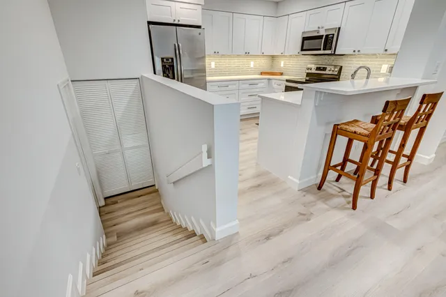 a kitchen with stainless steel appliances white cabinets and a refrigerator