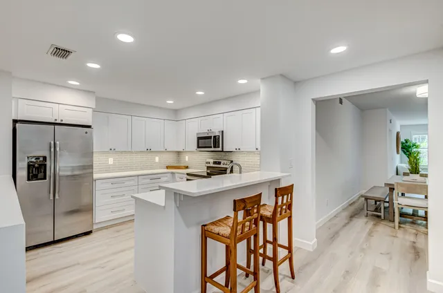 a kitchen with white cabinets stainless steel appliances and sink