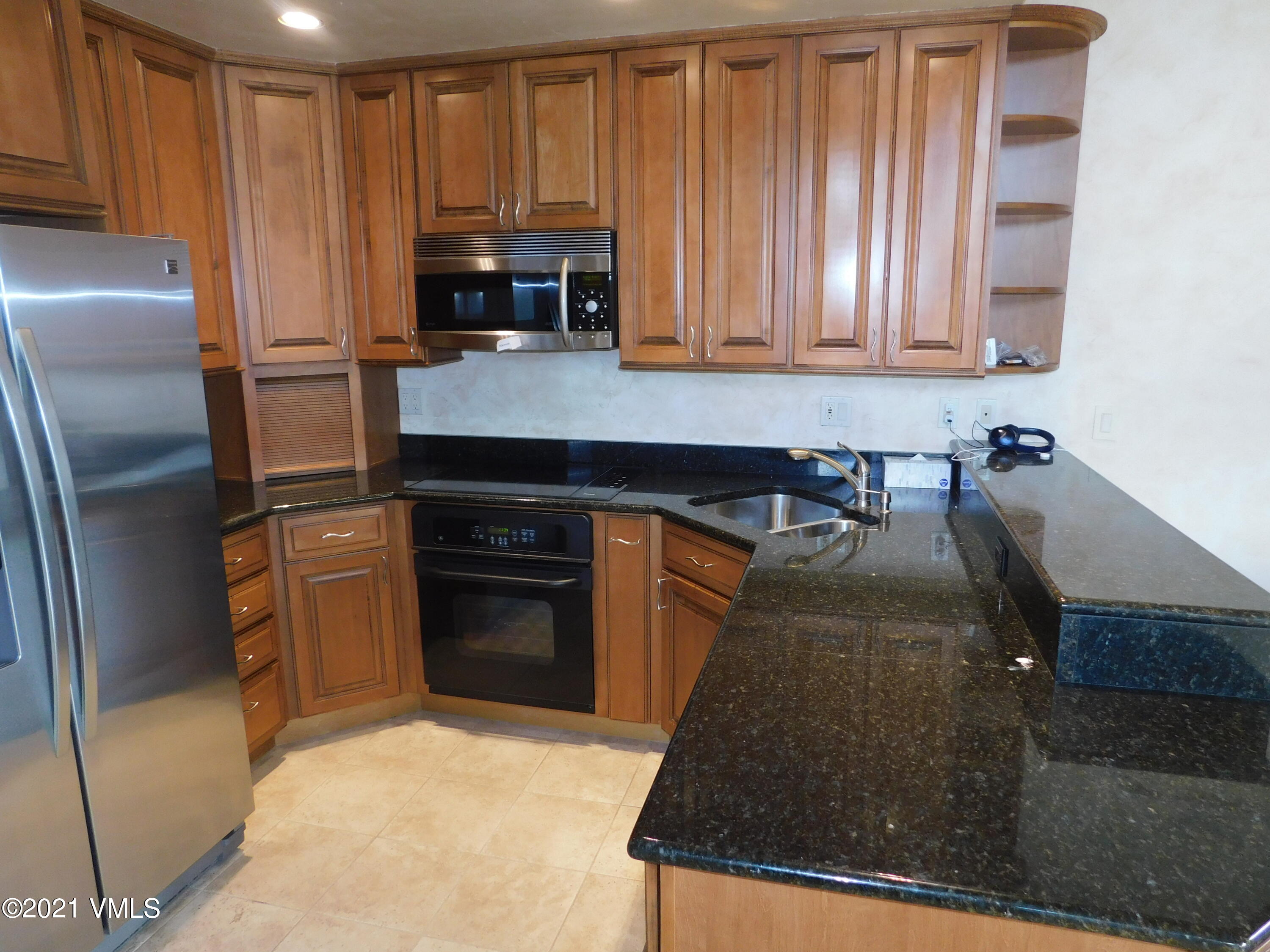 230 Nottingham Road, Unit A Avon, CO 81620 - Photo 3 of 12 a kitchen with granite countertop a refrigerator stove and cabinets