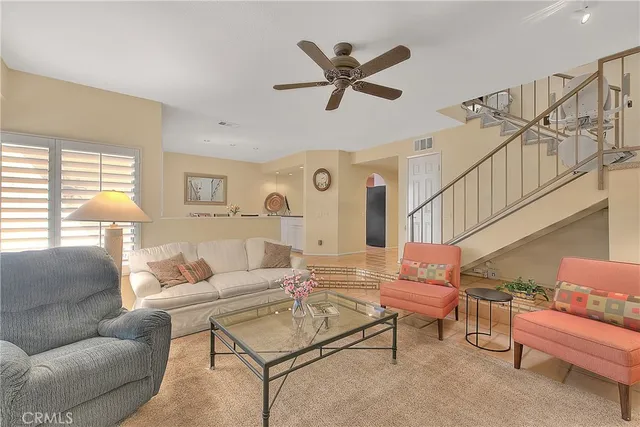 a living room with furniture ceiling fan and a fireplace