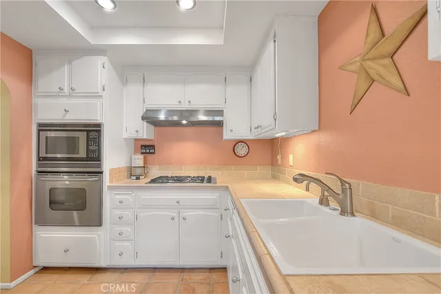 a kitchen with stainless steel appliances granite countertop a refrigerator and a stove top oven