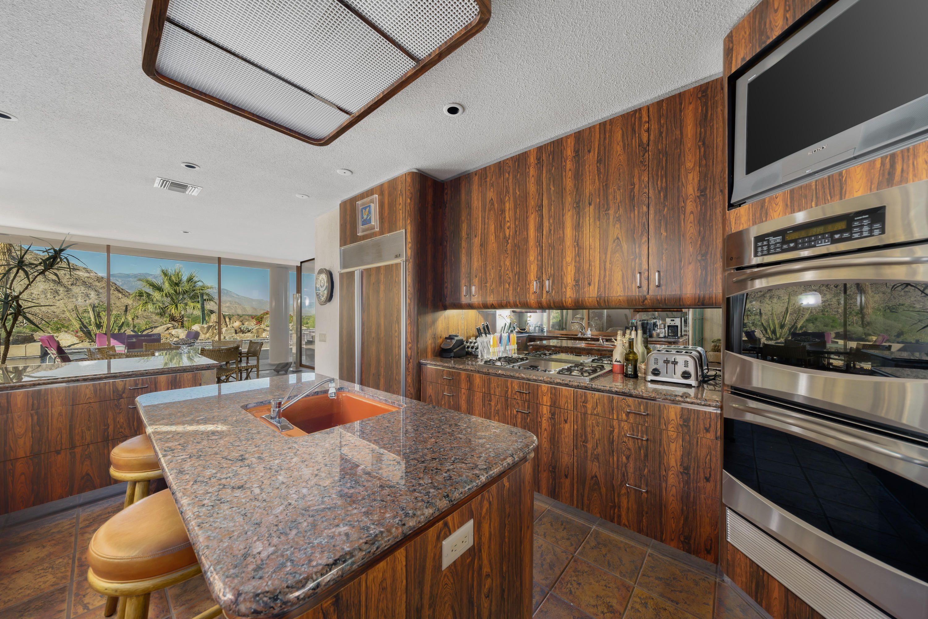 75270 Hidden Cove Indian Wells, CA 92210 - Photo 31 of 73 a kitchen with stainless steel appliances granite countertop a stove a sink a microwave and refrigerator