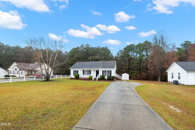 a view of a house with a yard and sitting area