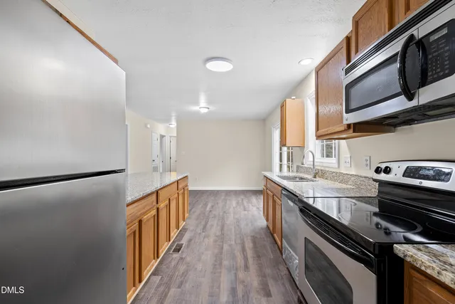 a kitchen with granite countertop a stove and a microwave