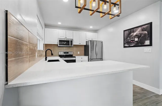 a kitchen with stainless steel appliances a refrigerator sink a microwave and cabinets