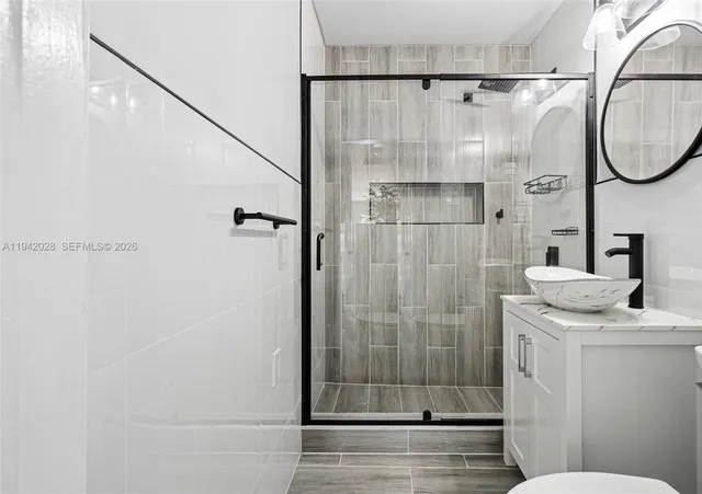 a bathroom with a granite countertop shower a sink and toilet