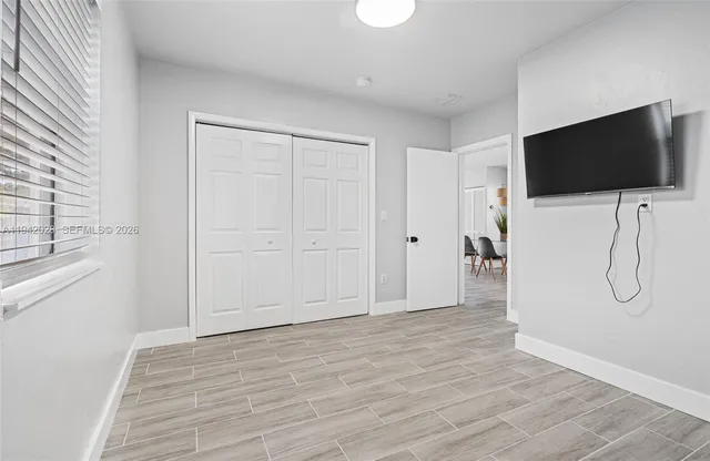 a view of a livingroom with wooden floor and a flat screen tv