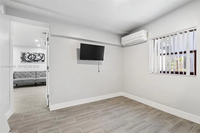 a kitchen with granite countertop a refrigerator stove a sink and white cabinets with wooden floor