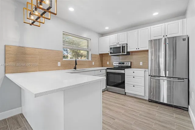 a kitchen with stainless steel appliances a refrigerator sink and microwave