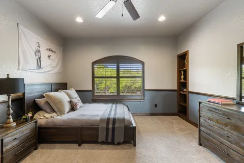 a bedroom with a large bed and a chandelier