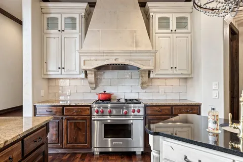a kitchen with stainless steel appliances granite countertop a stove and a wooden floors