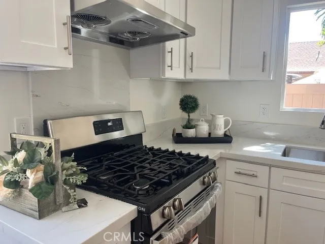 a kitchen with a stove and white cabinets
