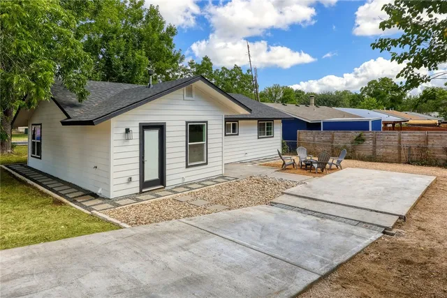 a view of a house with backyard and trees