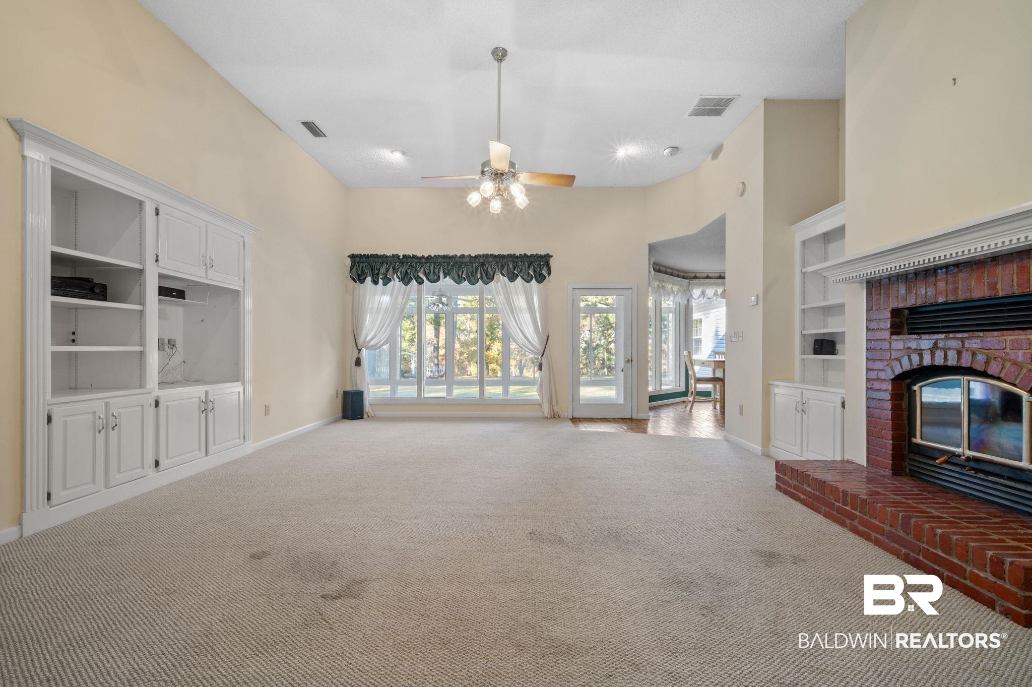 15801 Maytower Road Bay Minette, AL 36507 - Photo 9 of 43 Unfurnished living room with carpet flooring, ceiling fan, built in features, and a brick fireplace