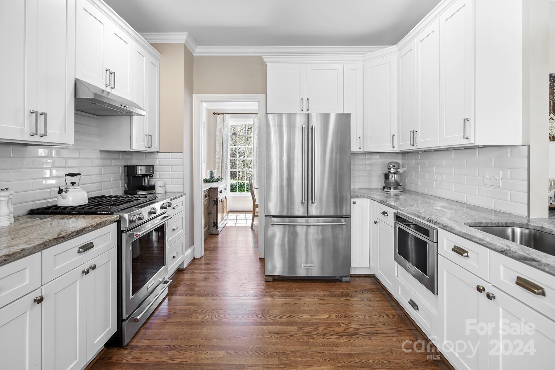 544 Ashby Drive Davidson, NC 28036 - Photo 11 of 40 a kitchen with stainless steel appliances granite countertop a refrigerator a stove a sink and white cabinets