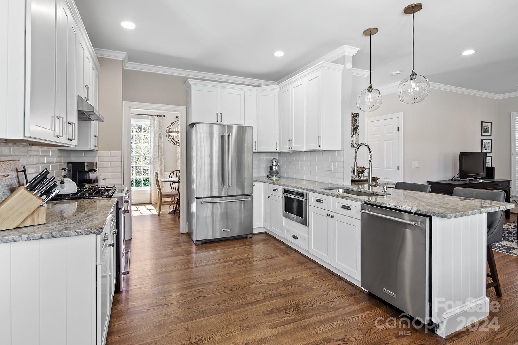 544 Ashby Drive Davidson, NC 28036 - Photo 12 of 40 a kitchen with stainless steel appliances and white cabinets
