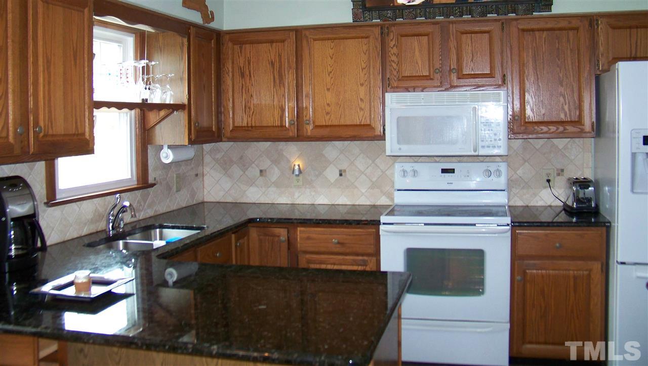 409 South Meadow Road Raleigh, NC 27603 - Photo 4 of 25 This kitchen is chef ready with beautiful granite countertops, a deep double sink with upgraded faucet, a smooth top range, built-in microwave and tile backsplash. It also has a tile floor, a pantry and plenty of oak cabinets.