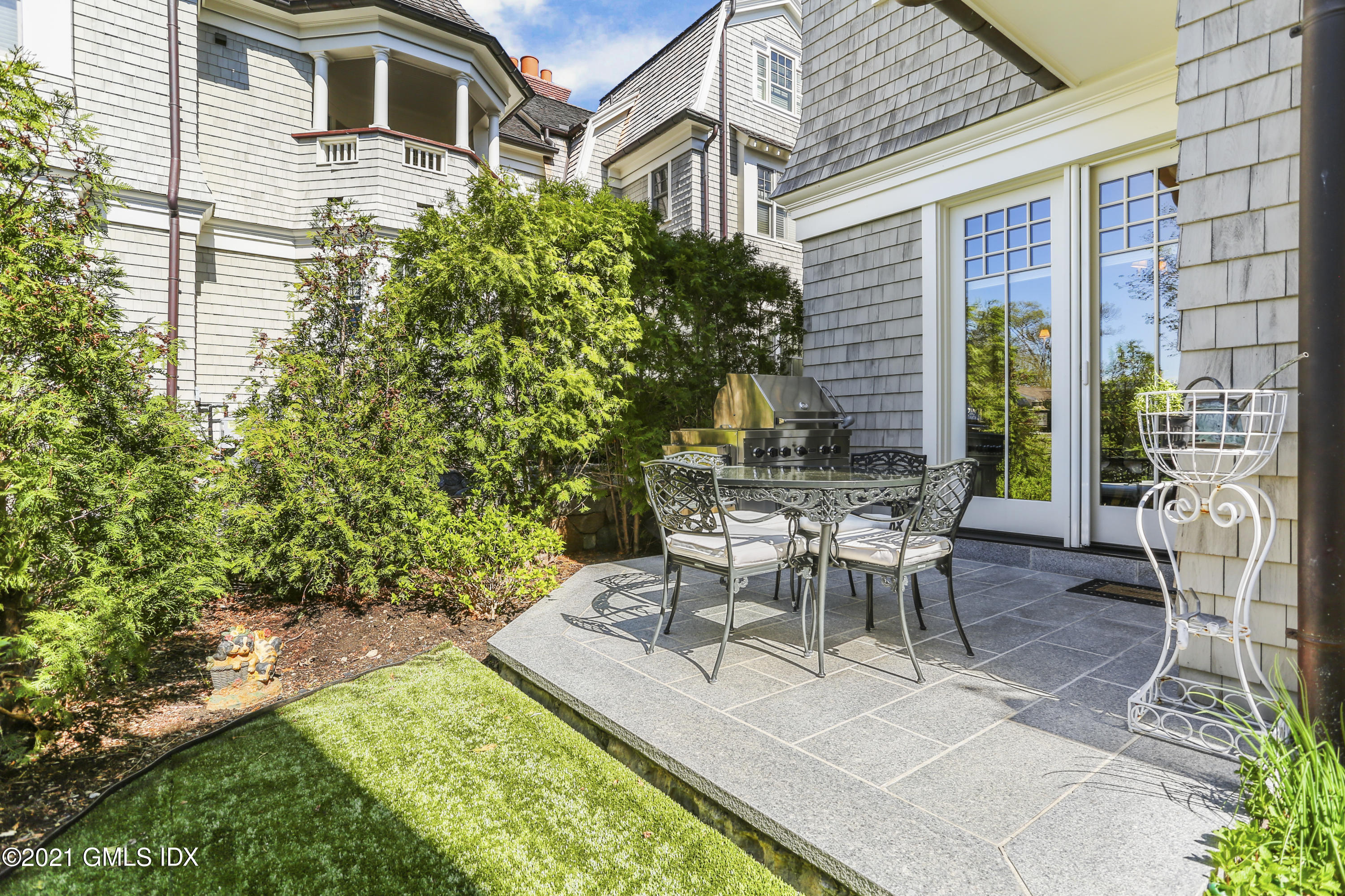 50 Sound View Drive, Unit 2 SOUTH Greenwich, CT 06830 - Photo 14 of 21 a view of a patio with table and chairs and potted plants