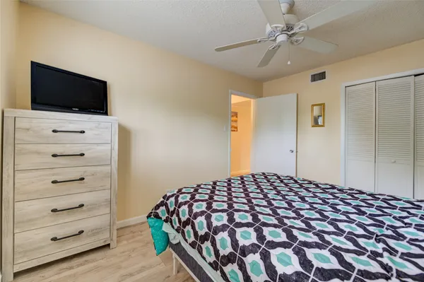 a bedroom with a bed and a flat tv screen on a dresser