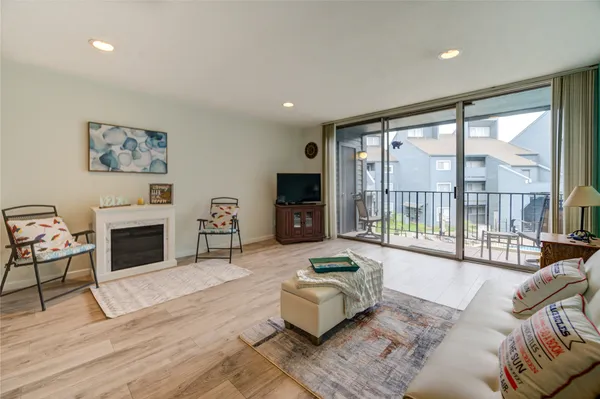 a living room with furniture large window and a fireplace