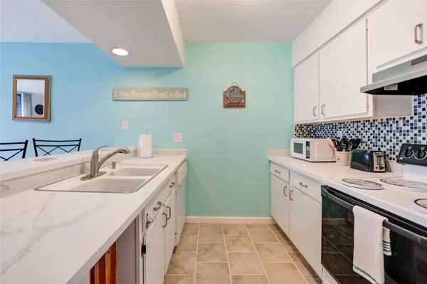 a kitchen with a sink stove and cabinets