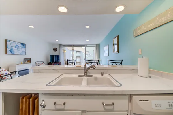 a kitchen with kitchen island a sink and a stove with wooden floor