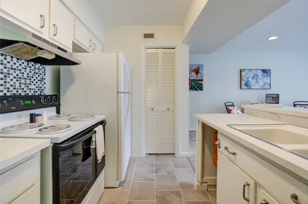 a view of kitchen with stainless steel appliances granite countertop a sink and a refrigerator