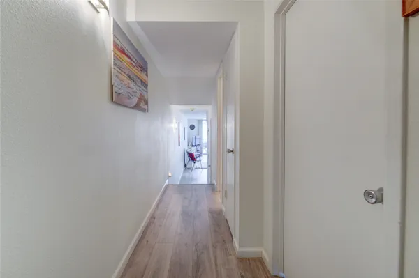 a view of a hallway with wooden floor