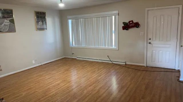 an empty room with wooden floor and a window