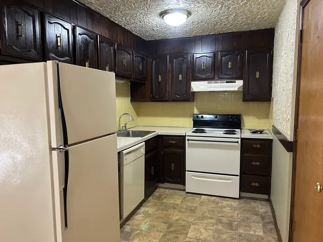 a kitchen with a refrigerator and a stove