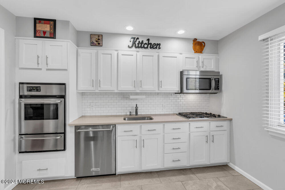 56 Bethany Road Holmdel, NJ 07733 - Photo 6 of 19 a kitchen with granite countertop white cabinets and stainless steel appliances