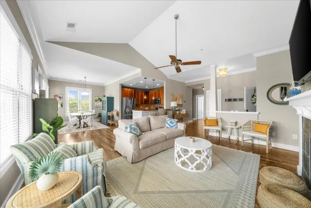 a living room with furniture kitchen view and a large window