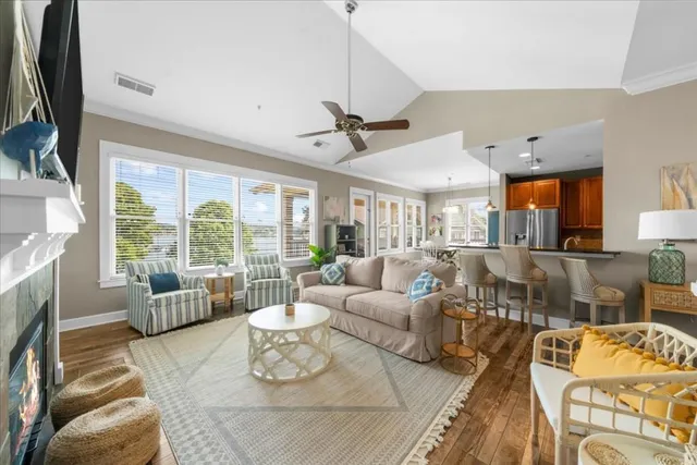 a living room with furniture ceiling fan and a large window