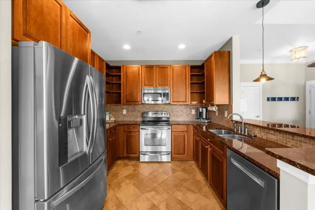 a kitchen with stainless steel appliances granite countertop a refrigerator a sink a stove and island