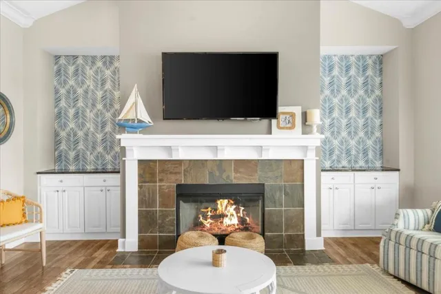 a living room with furniture a fireplace and a flat screen tv