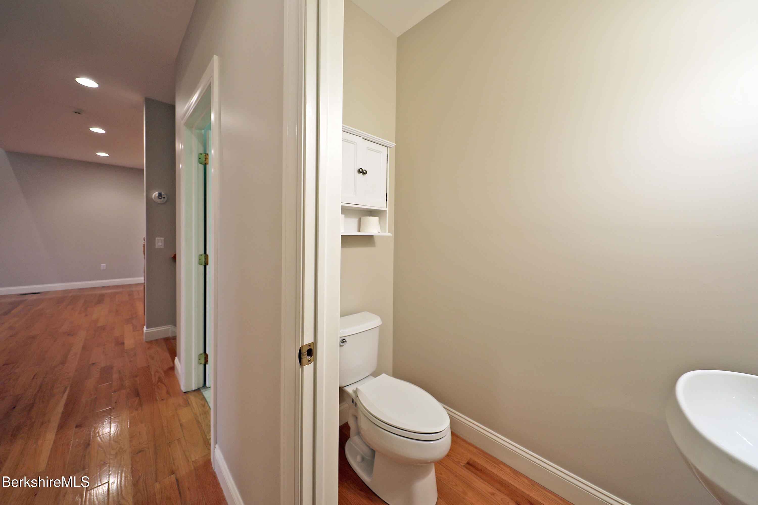 33 Alpine Trail Pittsfield, MA 01201 - Photo 25 of 69 a white toilet sitting next to a bathroom sink and a mirror