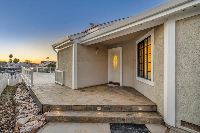 a view of a house with a yard and palm trees