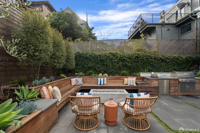 a view of a brick building with a yard and table and chairs
