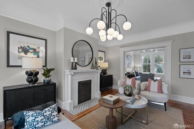 a living room with furniture a fireplace and a chandelier