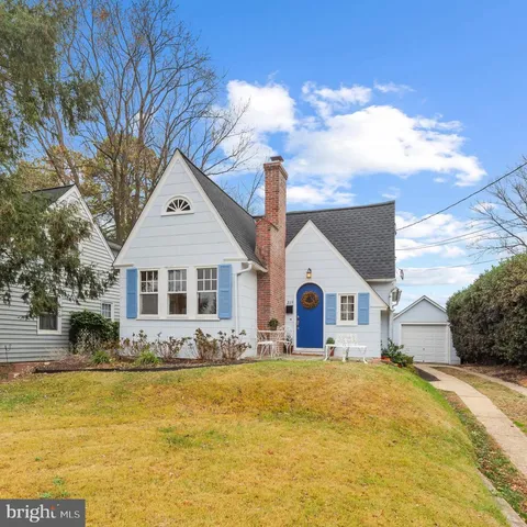 a front view of house with yard and trees in the background
