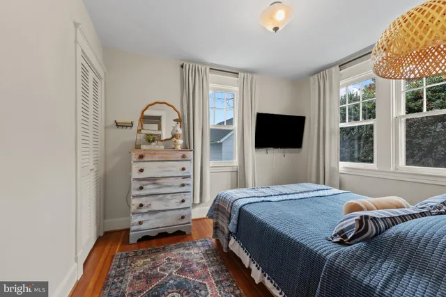a bedroom with a bed and a flat tv screen on dresser