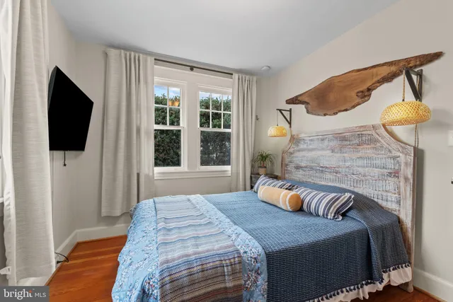 a bedroom with a bed and flat tv screen on the dresser