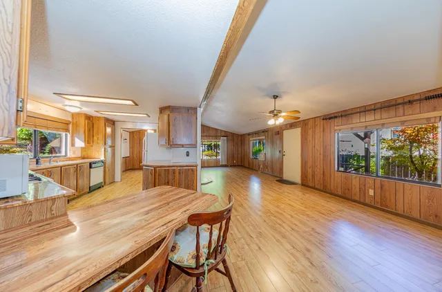 a view of a dining room with furniture a kitchen and chandelier