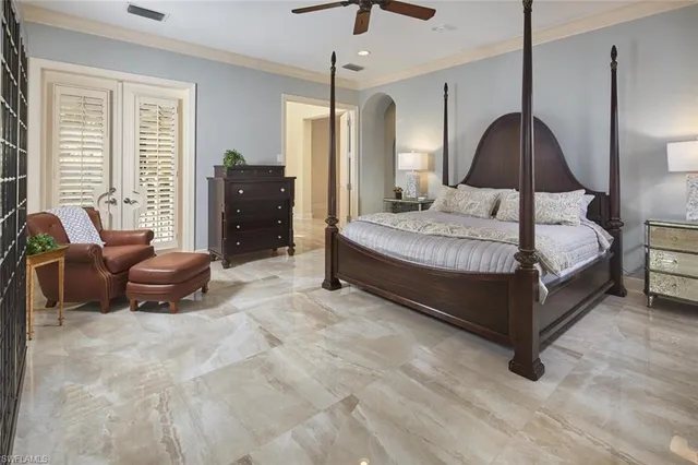 a spacious bedroom with a bed a couch and a chandelier