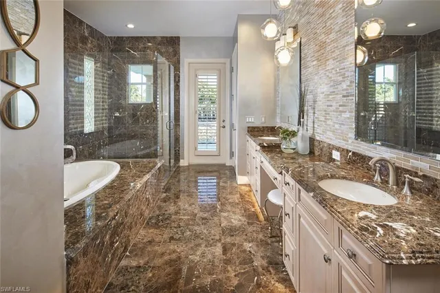 a spacious bathroom with a granite countertop sink a toilet a mirror and shower