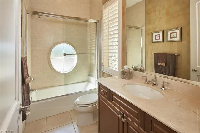 a spacious bedroom with a bed and a flat tv screen on a dresser