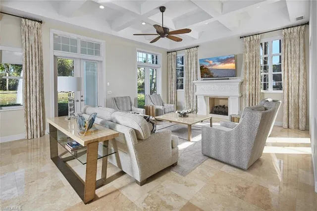 a living room with furniture a fireplace and a chandelier