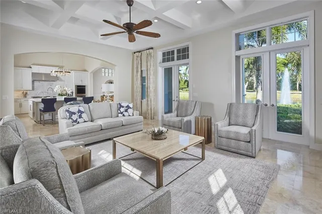 a living room with furniture a large window and a table