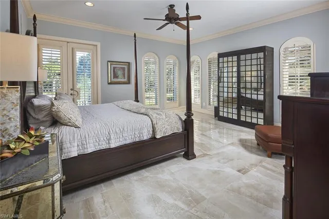 a bedroom with a bed wooden floor and windows