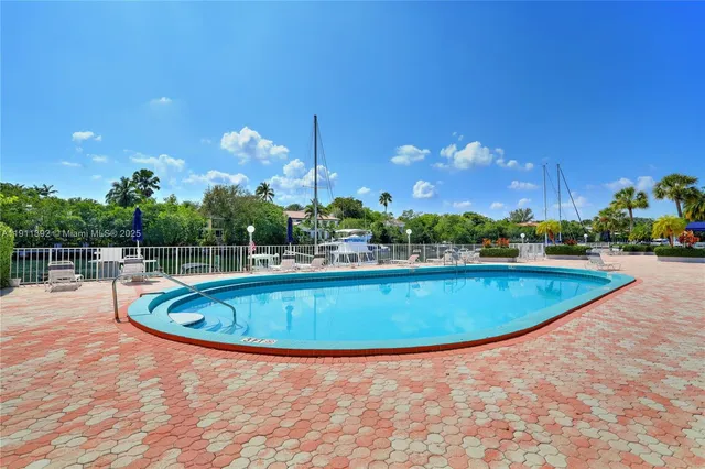 a view of a swimming pool with a yard and plants